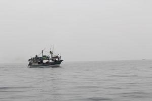 klein visvangst boot het zeilen in een Open Indonesisch zee tegen Doorzichtig lucht. foto