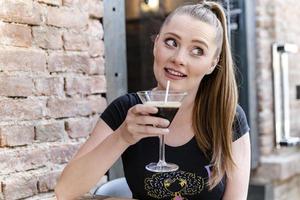 jong vrouw drinken alcohol cocktail met koffie bonen in het. foto