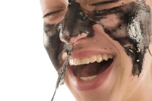 zwart gelaats masker. mooi meisje stapelen uit zwart masker. schoonheid concept foto