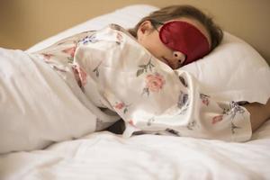 moe vrouw slapen in bed vervelend blinddoek slaap masker foto