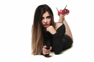 mooi vrouw met rood hoog heuvels Holding een pistool. geïsoleerd foto