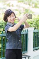 Aziatisch gir maakt zelfportret Aan smartphone foto