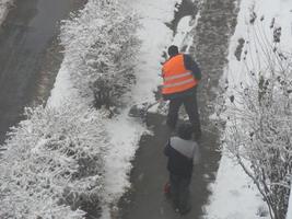 schoonmaak de straat met sneeuw ruitenwissers in winter foto
