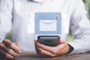 Mens lezing elektronisch mail van smartphone, e-mail afzet en nieuwsbrief begrip, digitaal communicatie met e-mail berichten, verzenden en ontvangen berichten online met de e-mail icoon foto