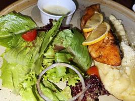 gerookt gegrild Zalm vis geserveerd met salade en puree aardappelen met citroenen foto