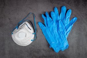 gasmasker masker en handschoenen Aan zwart achtergrond. masker bescherming tegen vervuiling, virus, griep en coronavirus 2019-nCoV. foto