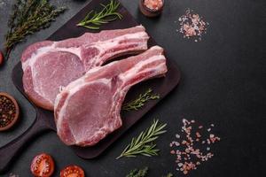 vers rauw varkensvlees vlees Aan de ribben met specerijen en kruiden Aan een houten snijdend bord foto