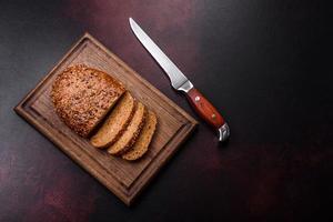 heerlijk krokant brood met granen Aan een houten snijdend bord foto