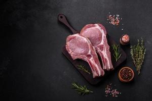 vers rauw varkensvlees vlees Aan de ribben met specerijen en kruiden Aan een houten snijdend bord foto