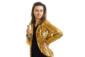 vrolijk brunette vrouw in gouden jasje met glas van champagne foto