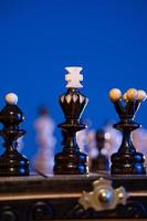 schaak bord met schaak stukken Aan blauw achtergrond. concept van bedrijf ideeën en wedstrijd en strategie ideeën. zwart koning en figuren dichtbij omhoog. foto