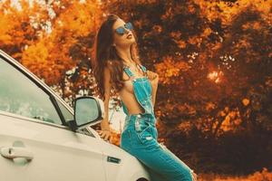 heet brunette in jeans overall en blauw zonnebril foto