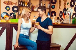 vent flirten met een blond in een bar en geeft haar een cocktail foto