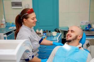 gelukkig tandarts en geduldig in de tandheelkundig kantoor foto