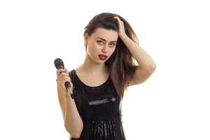 aantrekkingskracht brunette met maken omhoog het zingen een karaoke met microfoon foto
