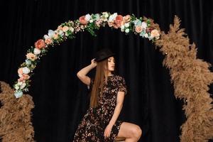 mooi vrouw poseren Bij cirkel van deadwood in jurk met bloem afdrukken foto
