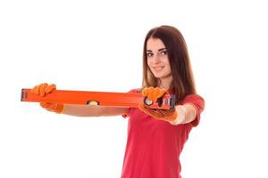 portret van jong schoonheid brunette gebouw vrouw in rood uniform met gereedschap in handen maakt vernieuwing en glimlachen Aan camera geïsoleerd Aan wit achtergrond foto