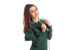 charmant brunette dame in groen jurk met microfoon foto