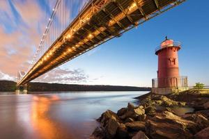 George Washington brug en de rood weinig vuurtoren in fort Washington park, nieuw york, ny in de avond. foto