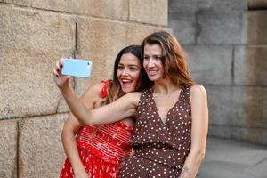 twee meisjes interactie met een mobiel telefoon en nemen dwaas selfie foto's in nieuw york stad foto