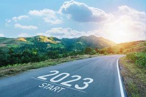 gelukkig nieuw jaar 2023,2023 symboliseert de begin van de nieuw jaar. de brief begin nieuw jaar 2023 Aan de weg in natuur route rijweg zonsopkomst hebben boom milieu ecologie of groen behang concept. foto