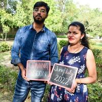 indiase paar poseren voor zwangerschaps baby shoot. het paar poseert in een gazon met groen gras en de vrouw pronkt met haar babybuil in de Lodhi-tuin in New Delhi, India foto