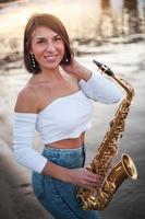 vrouw die saxofoon speelt bij zonsondergang foto