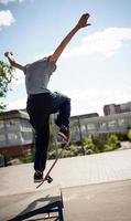 skateboarder doet de truc met een springen Aan de oprit. skateboarder vliegend in de lucht foto