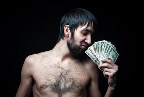 jonge man met bankbiljetten op zwarte achtergrond foto