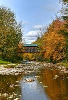 maalkoren molen gedekt brug in Cambridge, Vermont gedurende vallen gebladerte. foto