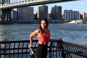 vrouw jogger uitrekken door de Manhattan brug in de Dombo Oppervlakte van Brooklyn in nieuw york stad foto