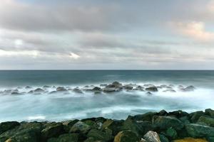 strand met golven kruispunt tegen de rotsen uit van san juan, puerto rico. foto