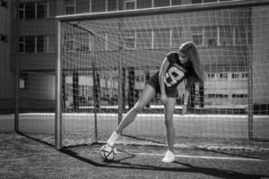 mooi meisje met bal Aan de voetbal veld- foto