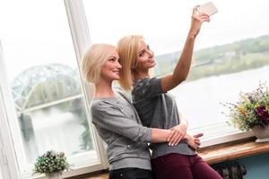 moeder en dochter nemen een selfie Bij huis foto