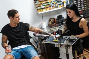 tatoeëren artiest gedurende haar werk foto