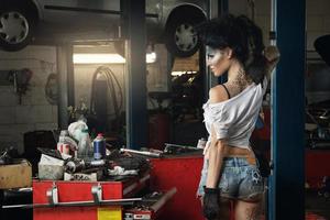 vrouw monteur in garage met artistiek bedenken Aan haar gezicht gestileerde Leuk vinden een vuil plek foto