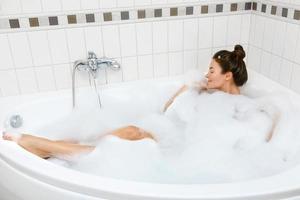 vrouw is nemen bad met een schuim foto