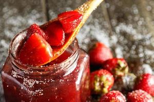 eigengemaakt zoet aardbei jam Aan houten tafel foto