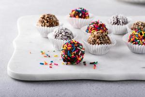 eigengemaakt chocola truffels gedekt met hagelslag en noten foto