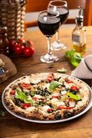 vers gebakken vegetarisch Napolitaans pizza met champignons en artisjokken foto