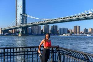 vrouw jogger uitrekken door de Manhattan brug in de Dombo Oppervlakte van Brooklyn in nieuw york stad foto