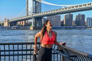 vrouw jogger uitrekken door de Manhattan brug in de Dombo Oppervlakte van Brooklyn in nieuw york stad foto