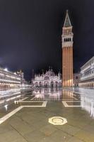 heilige mark's plein in Venetië Italië Bij nacht met reflecties in de water. foto