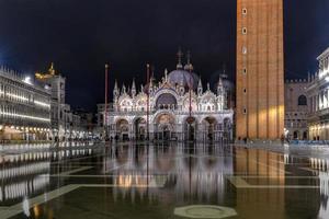 heilige mark's plein in Venetië Italië Bij nacht met reflecties in de water. foto