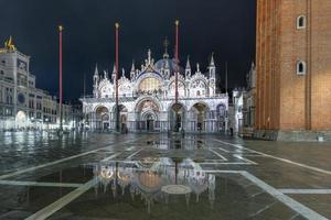 heilige mark's plein in Venetië Italië Bij nacht met reflecties in de water. foto