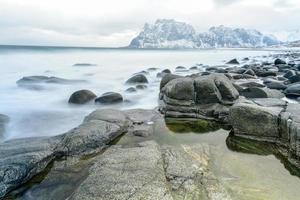 golven vloeiende over- utakleiv strand, lofoten eilanden, Noorwegen in de winter. foto