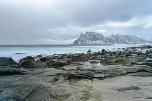 golven vloeiende over- utakleiv strand, lofoten eilanden, Noorwegen in de winter. foto