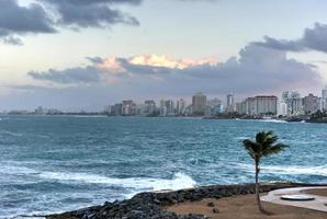 strand met golven kruispunt tegen de rotsen uit van condoom, san juan, puerto rico. foto