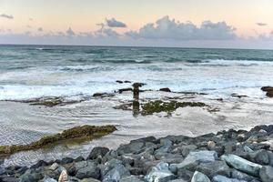 strand met golven kruispunt tegen de rotsen uit van san juan, puerto rico. foto