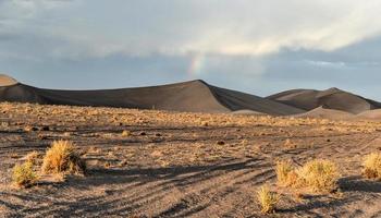regenboog te midden van zand duinen in de amargosa woestijn foto